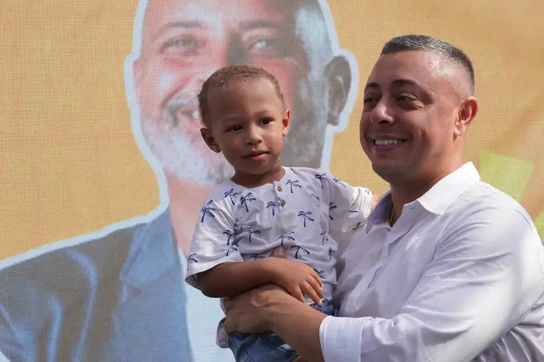 Gil Torres com uma criança no colo durante um evento de rua em Itaguaí.