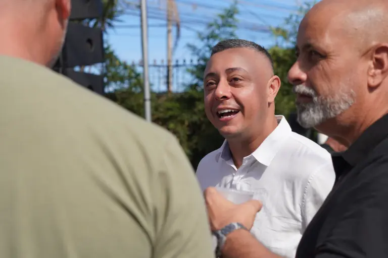 Gil Torres de frente para a câmera, em conversa com moradores durante um evento em Itaguaí.